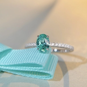 Détail macro d'une gemme Paraiba ovale sertie sur une bague en argent et diamants