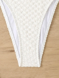 Detail of white bikini bottom featuring textured bubble fabric and premium stitching