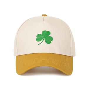 Detail of green shamrock embroidery on beige and yellow contrast baseball cap