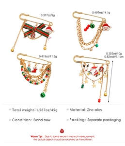 Detailed close-up of zinc alloy Christmas brooch set with enamel Santa and bell charms