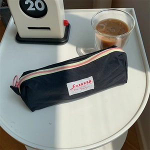 Macro shot of macaron pencil case on desk with coffee, showcasing trendy two-tone zipper