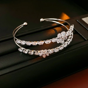 Vue macro d'un bracelet double couche argenté orné d'une fleur en zircon et de pampilles