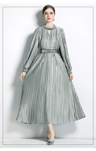 Detailed view of silver pleated dress featuring waist rhinestones and elegant long sleeves