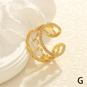 Detail of double-layer gold ring with white enamel heart and cubic zirconia accents
