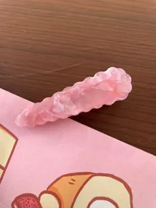 Detailed macro view of pink resin hair clip showing unique wrinkled frosted texture