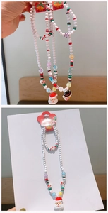 Detailed view of Christmas jewelry set with Santa charms and white beaded necklace