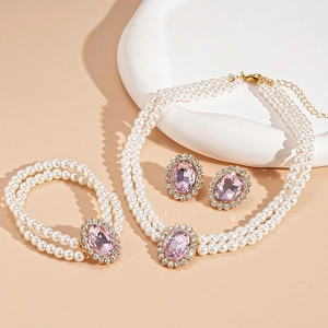 Close-up of elegant 3-piece pearl jewelry set with pink gemstones and gold-tone finish