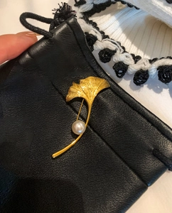 Dettaglio della spilla a foglia di ginkgo placcata oro 18K con venature e una perla bianca