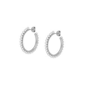 Detailed view of silver hoop earrings with white pearls in a minimalist metal frame