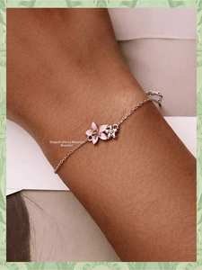 Close-up of pink cherry blossom charm and silver flower on a 925 sterling silver bracelet