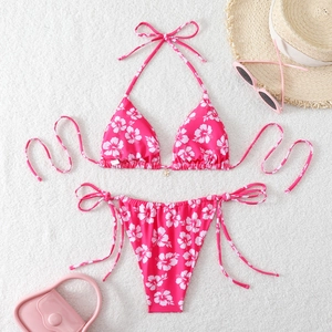 Detailed view of pink floral bikini set with tie-side bottom and beach accessories