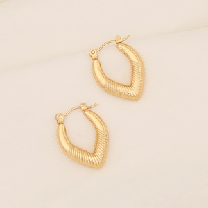 Detailed view of gold V-shaped textured earrings with ribbed metallic patterns