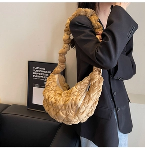 Fashionable bright yellow pleated cloud tote bag shown worn with a chic black blazer