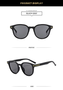Detail of square black-gray sunglasses showing gold T-shaped metal hinges and frame