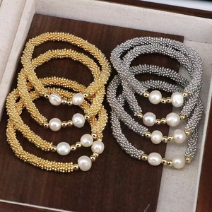 Elegant gold and silver beaded bracelets with freshwater pearls on a wooden display