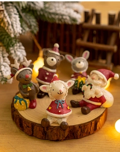 Detailed view of mini Christmas resin figurines including reindeer and bears on wood