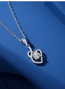 Macro shot of silver heart pendant featuring a large center stone and small accent diamonds