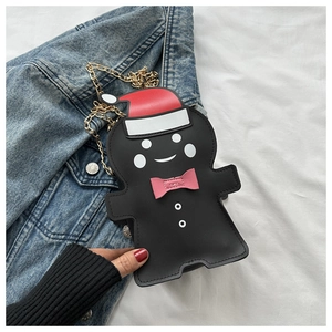 Close-up of black gingerbread man bag with gold chain and Christmas hat details