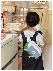 Detailed back view of a kids' daisy floral crossbody bag with adjustable white strap