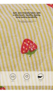 Detailed close-up of quilted strawberry pattern fabric on a striped yellow pillow bag