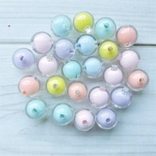 Macro shot of 16mm macaron colored round beads with holes on light blue wood