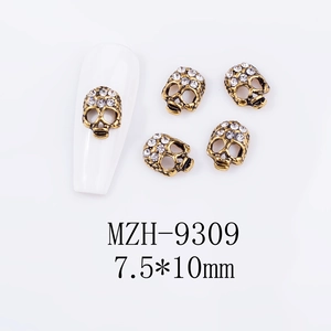 Close-up of vintage gold skull nail charms with rhinestones measuring 7.5x10mm