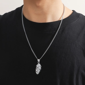 Men's stainless steel necklace featuring a detailed silver feather pendant on a male model