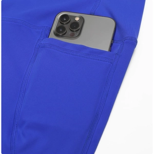 Detail view of royal blue yoga shorts featuring a side pocket for a large smartphone