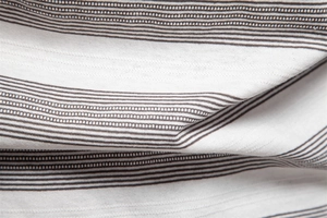 Gros plan sur le tissu en maille rayé blanc et gris montrant la texture délicate