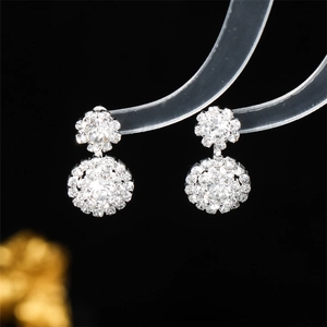 Macro view of crystal snowflake earrings with brilliant prong-set rhinestones on a stand