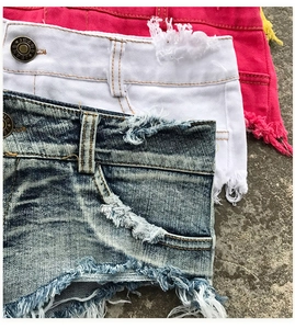Vista dettagliata di pantaloncini di jeans con bordi sfrangiati e bottoni metallici