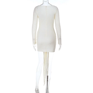 Details der weißen Spitzentextur und des Lochmusters auf dem langärmligen Minikleid