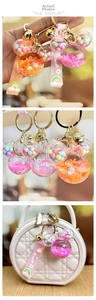 Detail of Mickey head shaker keychain with liquid sand, sequins and bell strap