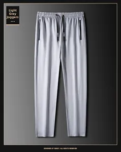 Detalle de pantalón deportivo gris claro con cintura elástica de cordón y bolsillos con cremallera