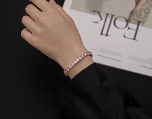 Dettaglio macro di un bracciale tennis in argento 925 con zirconi rosa da 5mm sul polso