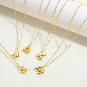 Close-up of 14K gold plated puffer initial pendants showing letter details and fine chain
