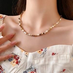 Close-up of a vintage freshwater pearl necklace with gold beads and faceted grey gems