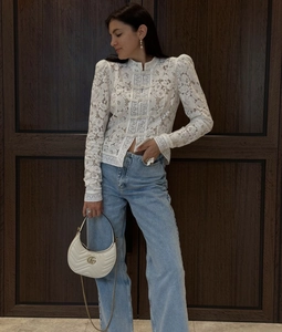 Detalle de la blusa de encaje blanco con botones chinos tradicionales y bordados elegantes