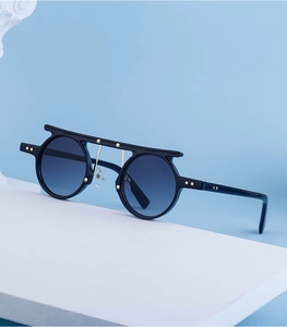 Close-up of black round sunglasses featuring gold star accents and top bar design