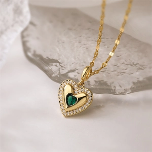 Close-up of heart pendant necklace with green gemstone and sparkling crystals