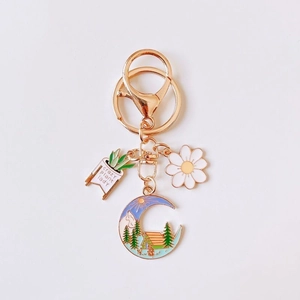Enamel plant lady keychain with daisy moon charms and gold lobster clasp on white background