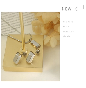 Détail d'une parure en argent avec collier pendentif et boucles d'oreilles rectangulaires