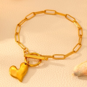 Detail of 18k gold plated stainless steel paperclip chain bracelet with heart charm and OT buckle