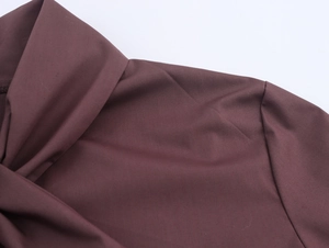 Detail view of the stitching and smooth fabric texture on the maroon long sleeve top