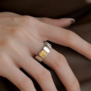 Detailed view of bicolor enamel daisy open ring with gold relief on female hand