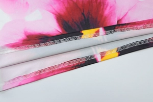 Gedetailleerde macro-opname van de levendige bloemenprint en de zoomstiksels op de jurk