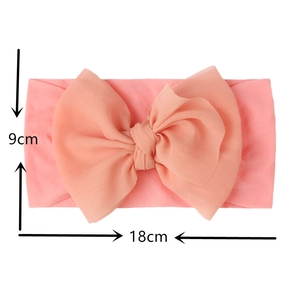 Pink nylon baby turban headband with large bow detailing, measuring 18cm by 9cm in size