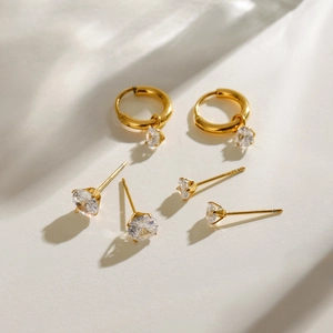 Lot de trois paires de boucles d'oreilles en acier doré avec zircons et anneaux