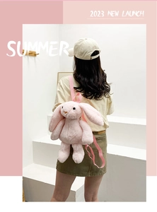 Rear view of a model wearing a soft pink plush bunny backpack with long ears and straps