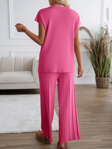 Rückansicht eines lässigen rosa Strickpullovers und einer weiten Hose für Damen